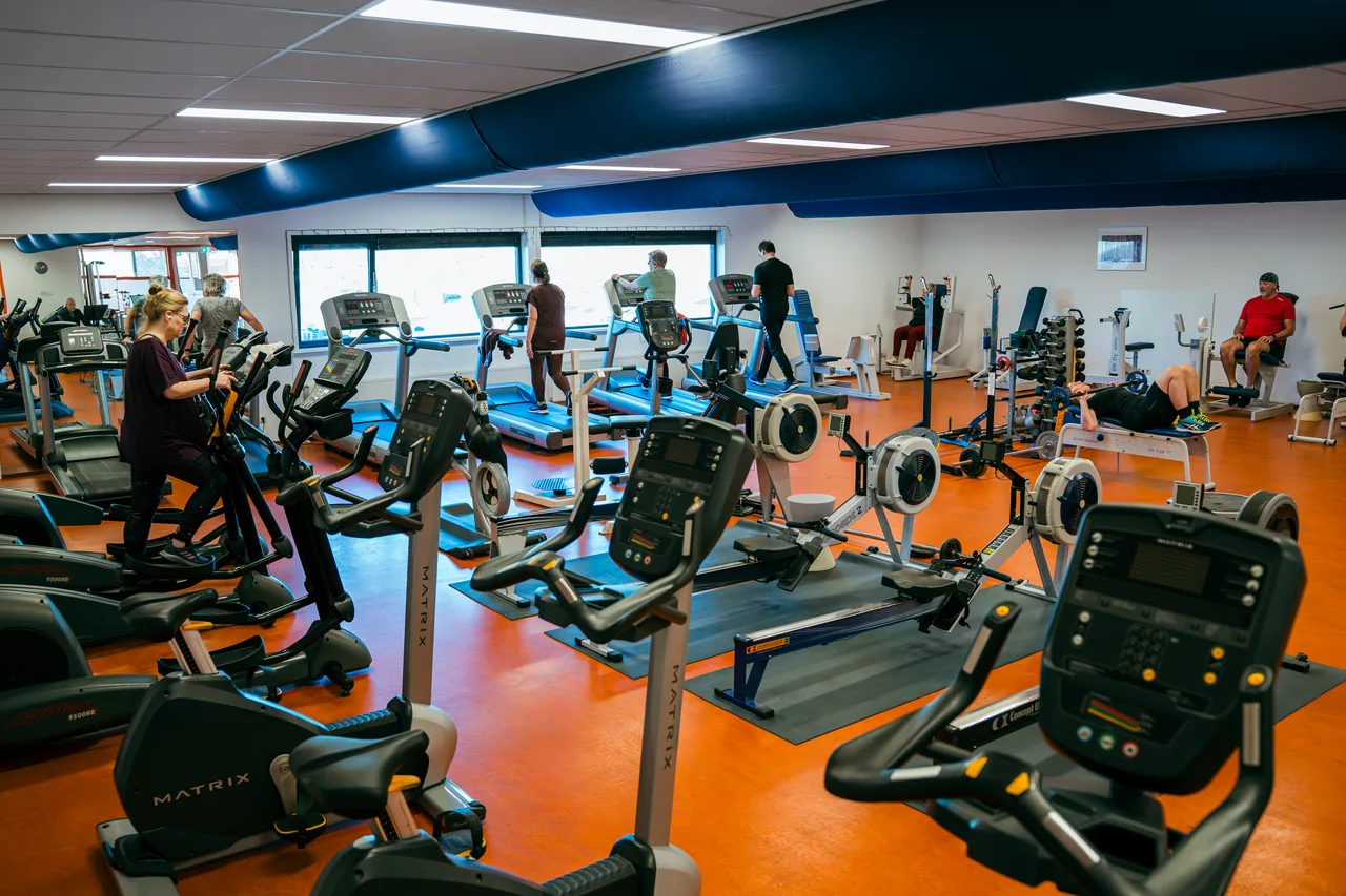 De trainingszaal met cardio- en krachtapparatuur